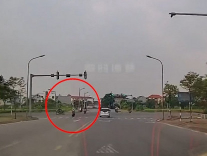 Giao thông - Clip: Vượt đèn đỏ đâm vào người khác, thanh niên đi xe máy suýt chui gầm ô tô