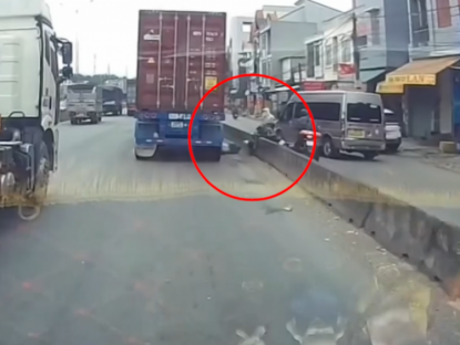 Giao thông - Clip: Rùng mình cả gia đình thoát nạn trong gang tấc dưới bánh xe container