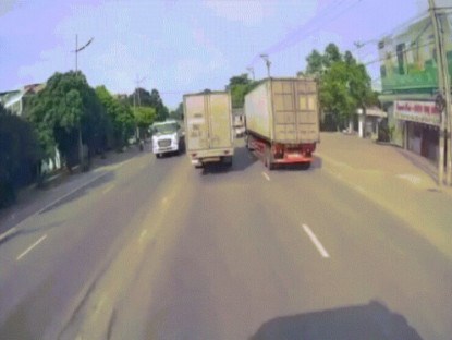 Giao thông - Clip: Hết hồn thanh niên định "xuyên không" giữa ô tô tải và đầu kéo