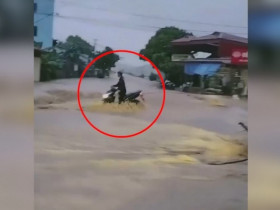 Clip: Thót tim thanh niên bất chấp nước lũ cuồn cuộn, liều mình lao xe ra đường