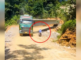 Clip: Hết hồn người đàn ông phóng xe máy chui dưới dầm bê tông xe đầu kéo