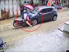 Clip: Cầm ô chạy xe máy giữa mưa, thanh niên lao thẳng vào ô tô đối diện